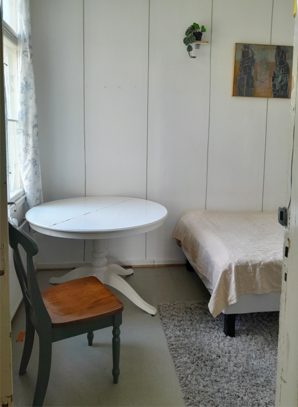 A small room with a table, a bed and chair