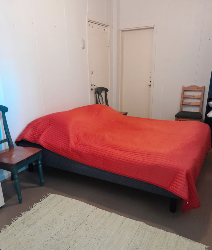 A bed with a red blanket on it