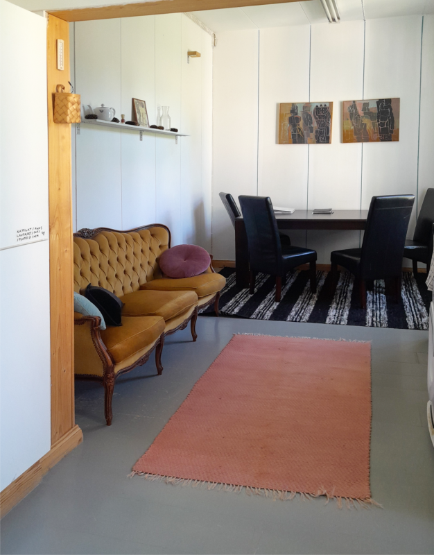 A room with a couch, table with four chairs and a rug