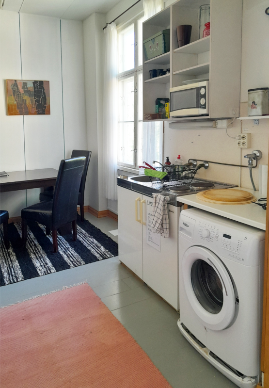 A kitchen with a washing machine and a table